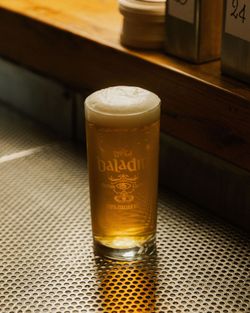 Ein Glas baladin Craft Beer mit Schaum steht auf einem Metalltisch in der Bar von Open Baladin Roma.