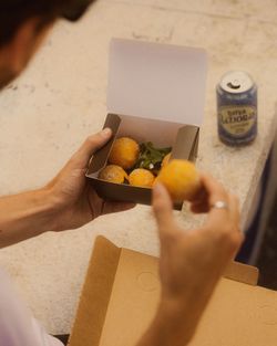 Palline fritte servite in una scatola di cartone con lattina di birra artigianale Baladin sullo sfondo.