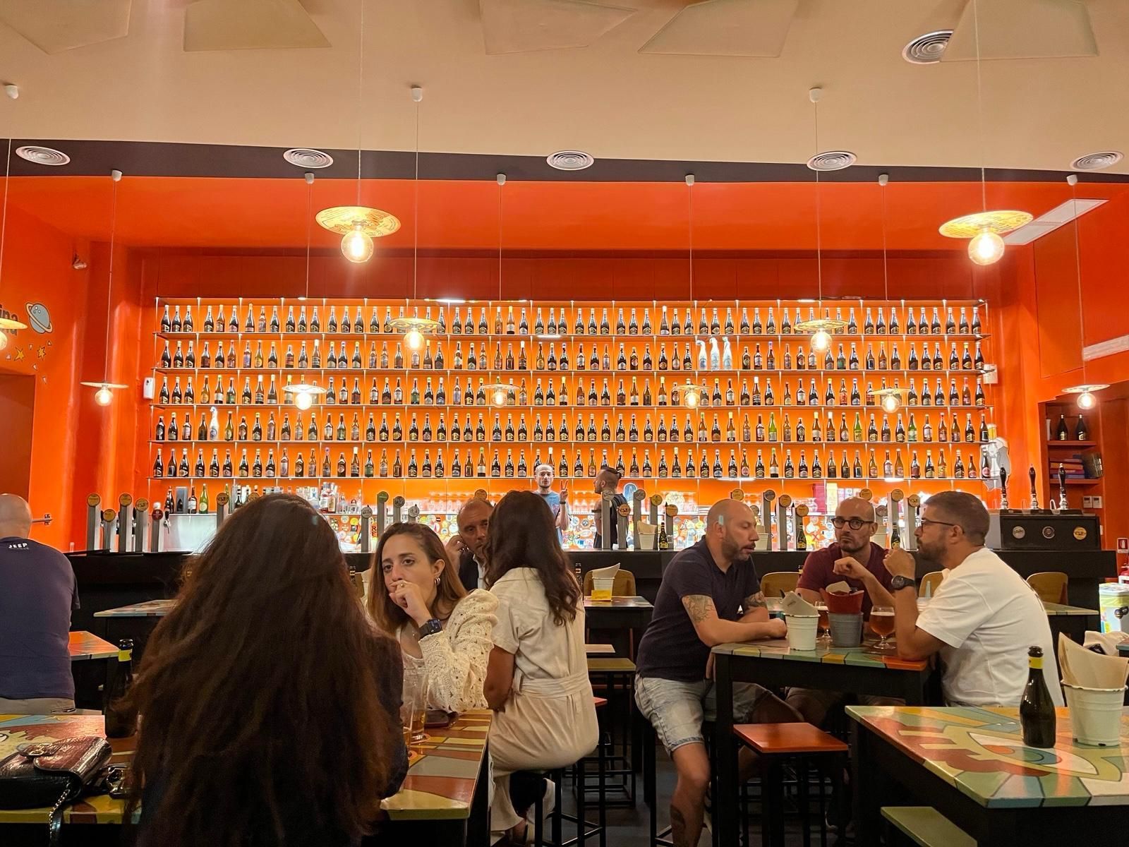 Una vista interna di Open Baladin Roma, con un'ampia selezione di birre artigianali esposte sullo sfondo.