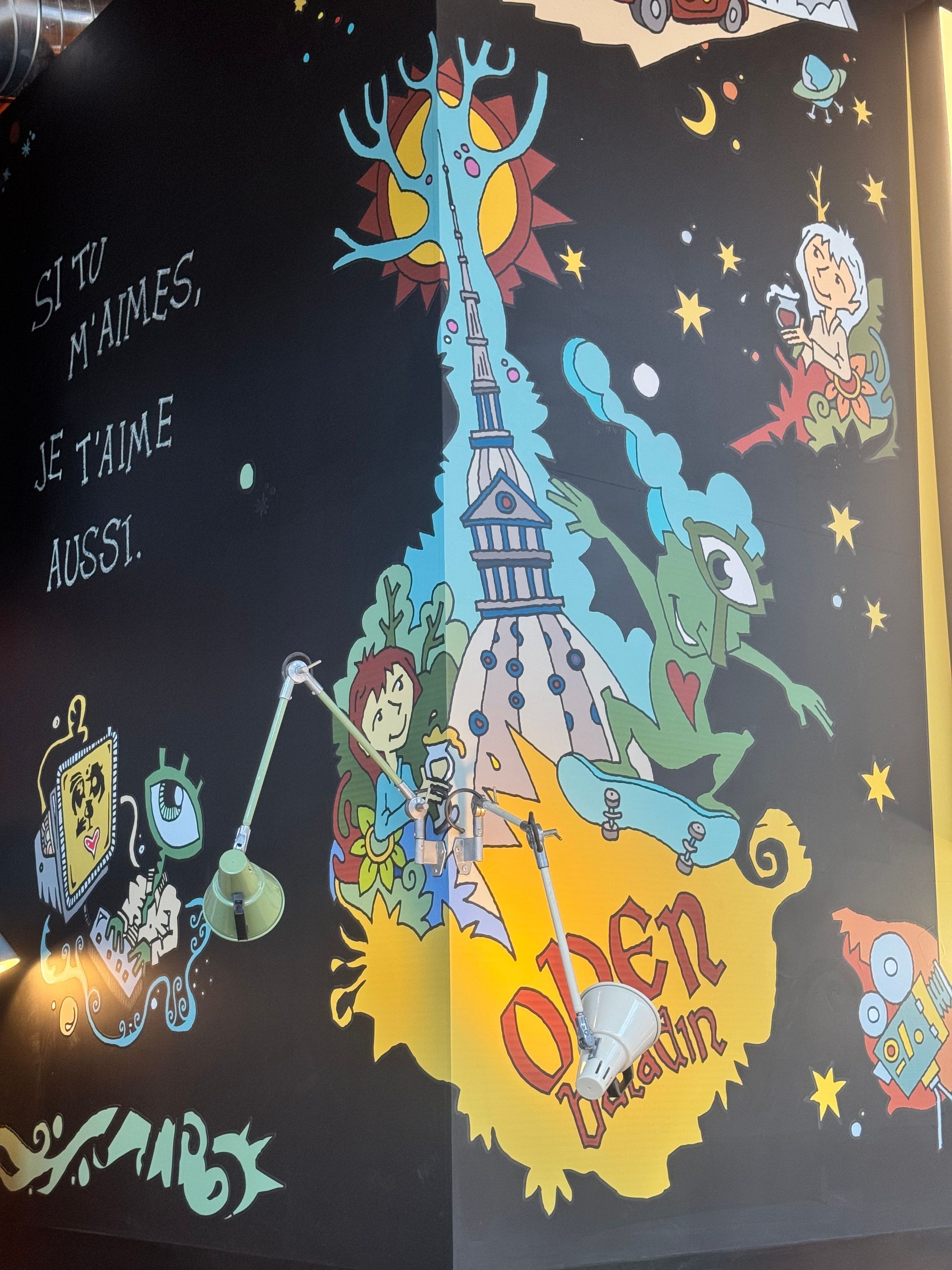 Mur décoré d'une fresque colorée avec le logo Open Baladin, des personnages dessinés et un texte en français.