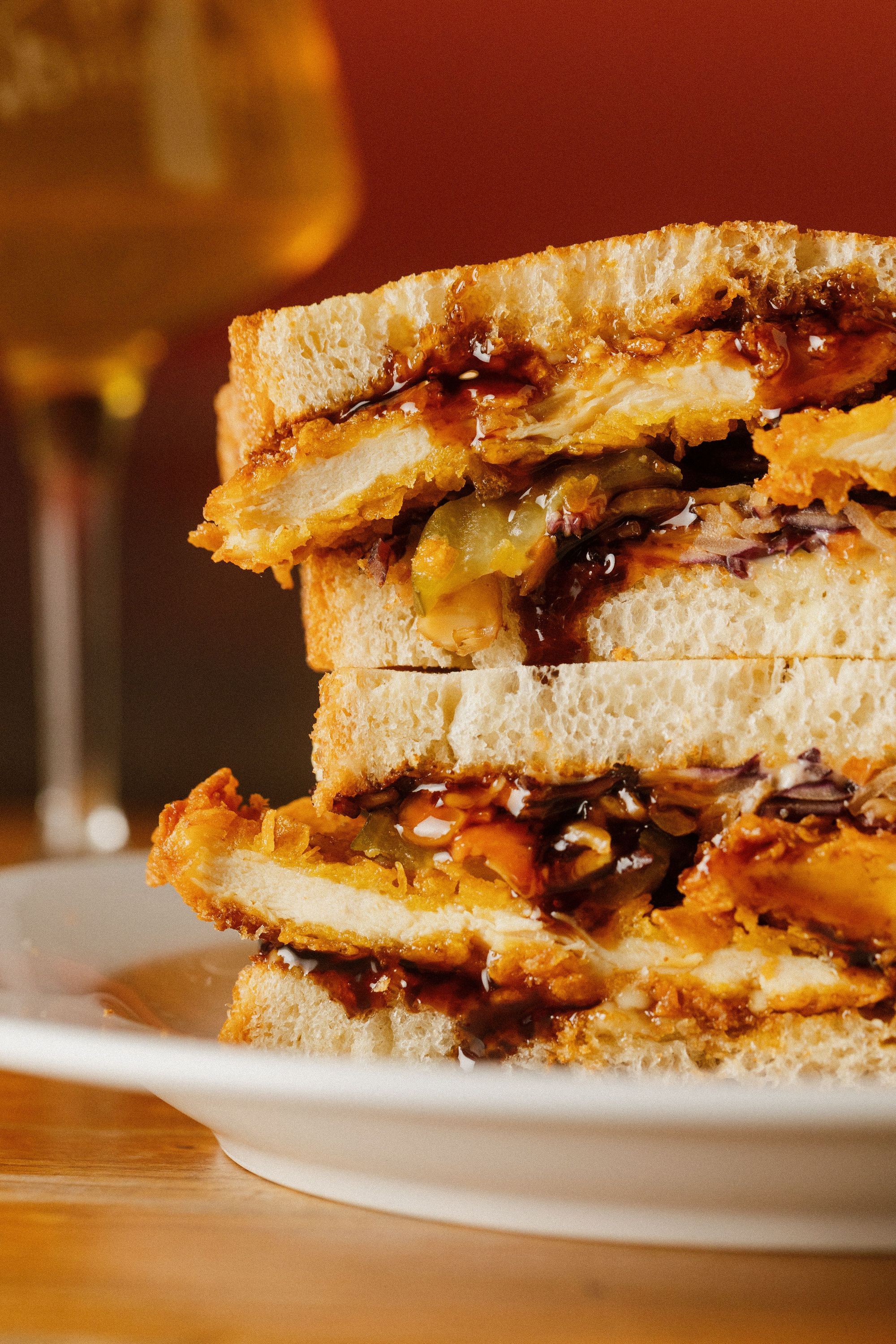 Burger croustillant avec garniture entre deux tranches de pain, accompagné d'un verre de bière artisanale
